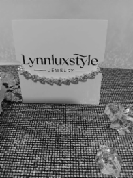 LYNNLUXSTYLE JEWELRY THE HORIZONTAL RULE ACCENT ABOVE THE LETTERS OF STY, AND THE DIVIDER LINE IN FRONT OF THE J AND AFTER THE LETTER Y